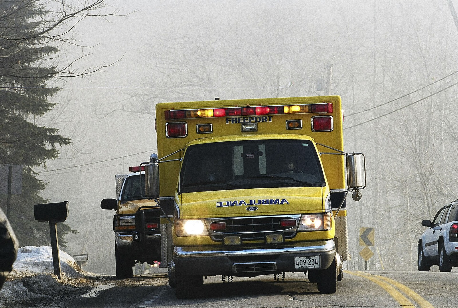 A Freeport, Maine municipal ambulance on a foggy rural road